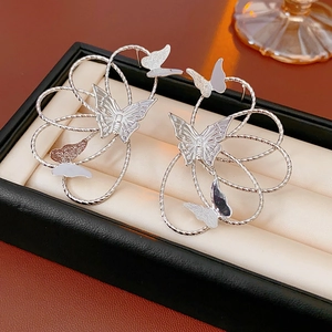 Detailed view of silver hollow butterfly earrings displayed in a black jewelry gift box
