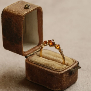 Vintage gold ring with three orange garnets in an antique jewelry box display