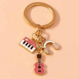 Detailed macro view of golden keychain with pink guitar, piano and headphone charms