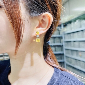 Gros plan de boucles d'oreilles pendantes en cristal carré jaune et blanc