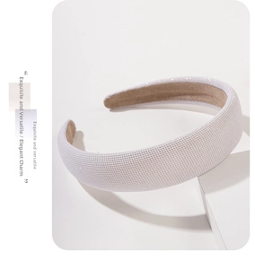 Close-up of white padded headband featuring shimmering mesh fabric and non-slip lining