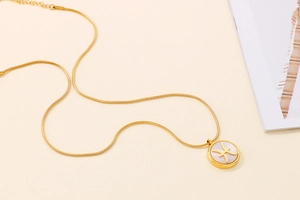 Macro view of gold Pisces zodiac necklace featuring a pearl shell inlay pendant