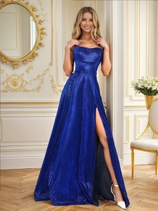 Detail of royal blue sequined evening gown with high slit and shimmering fabric