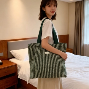 Close-up of a green woven canvas tote bag with a woven texture and branded label detail