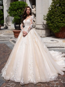 Detail of delicate lace floral embroidery on long-sleeved ivory tulle wedding dress