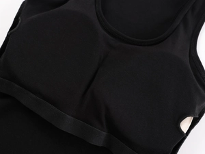 Detail view of the black sports bra interior with built-in pads and elastic hem