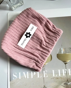 Detail of pink corduroy lipstick pouch with Free Travel label on stylish magazine background