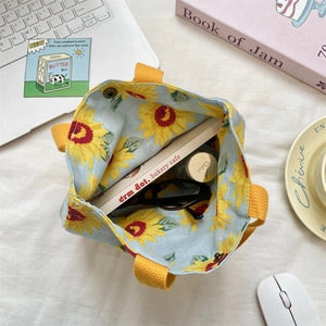 Detail of light blue sunflower canvas tote bag showing interior space and snap button