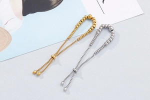 Detail of adjustable gold and silver beaded bracelets with sliding toggle closure