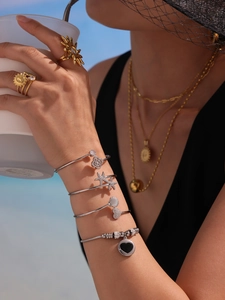Vue détaillée des colliers dorés et des bracelets à breloques argentés avec zircons