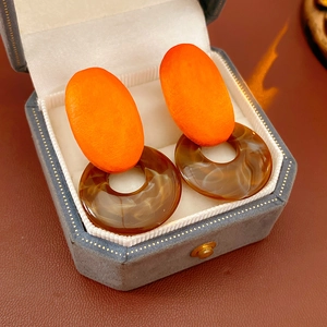 Close-up of geometric resin earrings with marble texture in a velvet jewelry gift box