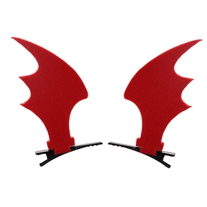 Close-up of red demon bat wing hair clips with black metal duckbill clips on white background