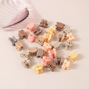Detailed view of mini matte hair claw clips in assorted pastel colors for hair styling