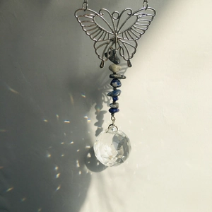 Detailed view of crystal ball suncatcher reflecting rainbow light spots on wall