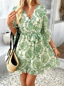 Detail of green floral chiffon dress featuring V-neckline and adjustable waist tie