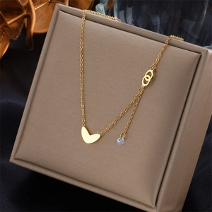 Gros plan détaillé du collier cœur plaqué or avec chaîne sertie sur une boîte beige