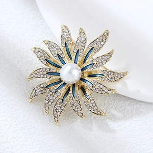 Macro detail of sunflower brooch with blue enamel petals and a large center pearl