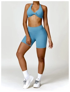 Detail of sky blue halter sports bra with twist front and high-waist yoga shorts