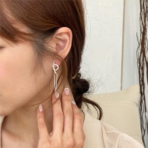 Detail of 925 sterling silver knot earrings with dangling fine chains on model