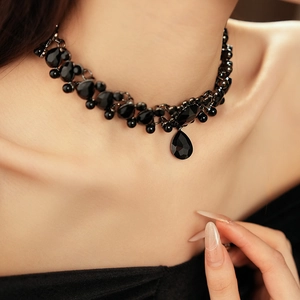 Detail of vintage black pearl choker necklace with a teardrop pendant worn on neck