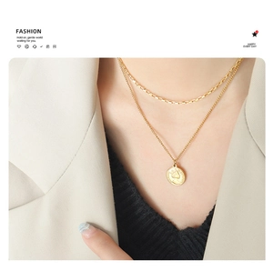 Detailed view of gold double-layered necklace featuring a queen portrait coin pendant