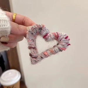 Close-up of colorful crochet heart hair claw clip with plush knit texture for women