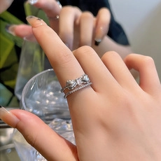 Close-up of double-layered silver ring with cubic zirconia bow and polished finish
