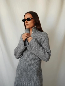 Detail eines grauen Strickkleids mit vertikaler Textur und Knopfverschluss am Kragen