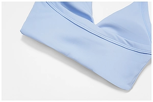 Detail of light blue high-stretch yoga top showing side stitching and smooth fabric texture