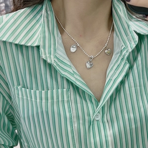 S925 sterling silver beaded necklace with vintage heart and round charms on a model