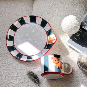 Macro shot of hand-painted puppy ceramic mug and striped plate set on festive background