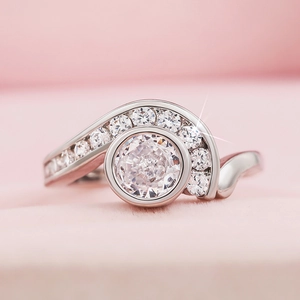 Detalle macro de anillo de plata ondulado con circón central y piedras laterales pequeñas