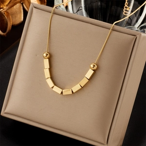 Minimalist gold tassel chain necklace with butterfly heart pendant on beige satin box