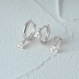 Detailed view of three silver S925 earrings with sparkling triple diamond triangle studs