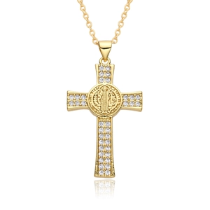 Macro shot of gold cross pendant with white crystals and Saint Benedict medal detail