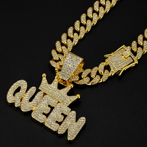 Close-up of golden Cuban chain with rhinestone encrusted QUEEN and crown pendant