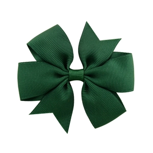 Detailed view of forest green ribbed polyester ribbon layers on a kids bow clip