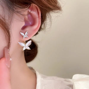 Detail of sweet double butterfly earrings with gold plating and white pearl finish