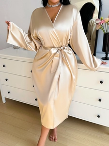 Detail of elegant champagne satin bathrobe showing smooth texture and v-neck belt closure