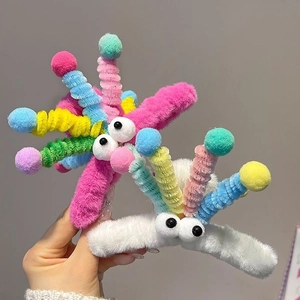 Hand holding funny monster plush hair claw clip with colorful spring tentacles