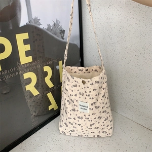 Detail of vintage floral canvas tote bag with magnetic closure and brand label