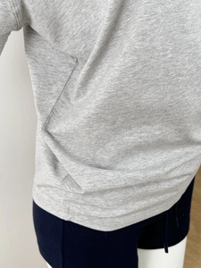 Detail view of grey off-shoulder knit T-shirt showing fabric texture and seam stitching