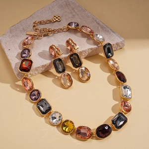 Luxurious geometric rhinestone sweater necklace and earrings set on a grey stone slab