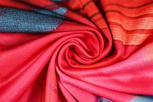Detailed close-up of vibrant multi-color print knit fabric with soft texture and drape