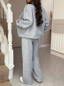 Rear view of women's grey knitted lounge set featuring a zip hoodie and wide-leg trousers