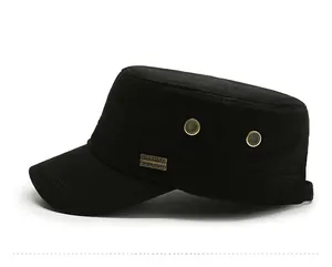 Detail view of black military cap featuring vintage gold eyelets and metal logo plate