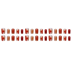 Short red cat eye press-on nails with gold floral designs on white background