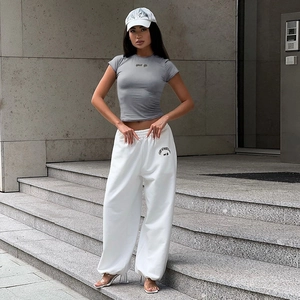 Ensemble sport femme avec t-shirt gris slim et pantalon blanc taille haute style urbain chic