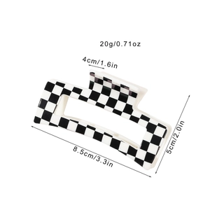 Black and white checkerboard hair claw clip measuring 8.5cm by 5cm for retro styling