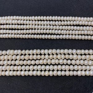 Close-up of high luster natural freshwater pearls in various sizes on a dark background
